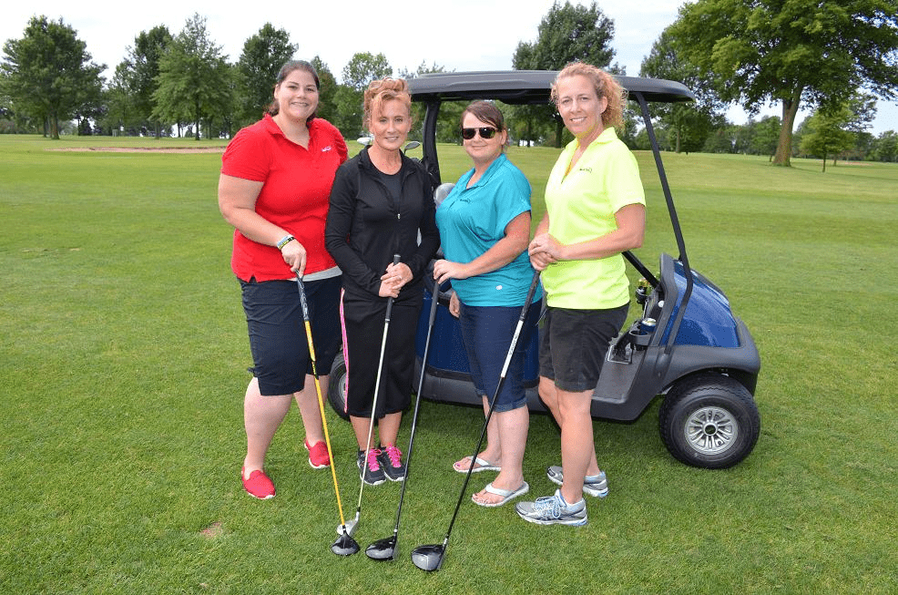 Group of four female golfers posing for a photo