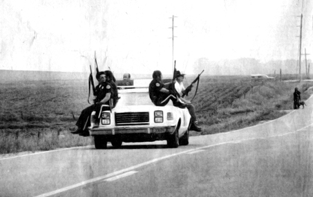 Deputies riding on car with guns