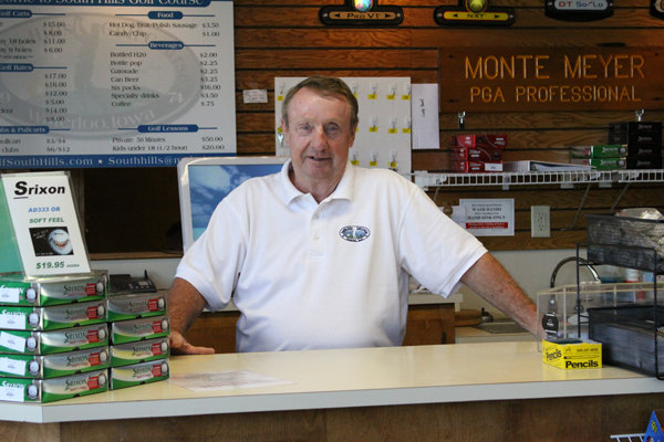 Man stands behind counter in golf store