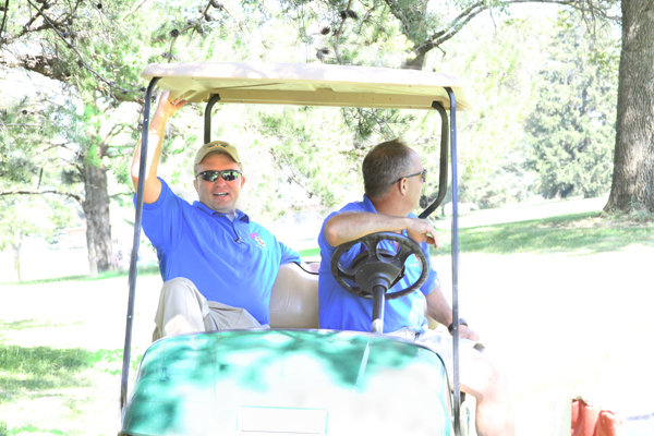 Sheriff Thompson and Deputy Stafford ride in golf cart together