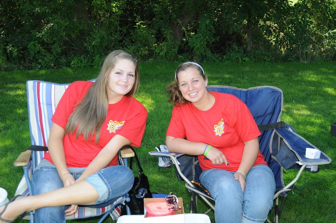 Two women in lawn chairs sit outside on the golf course together