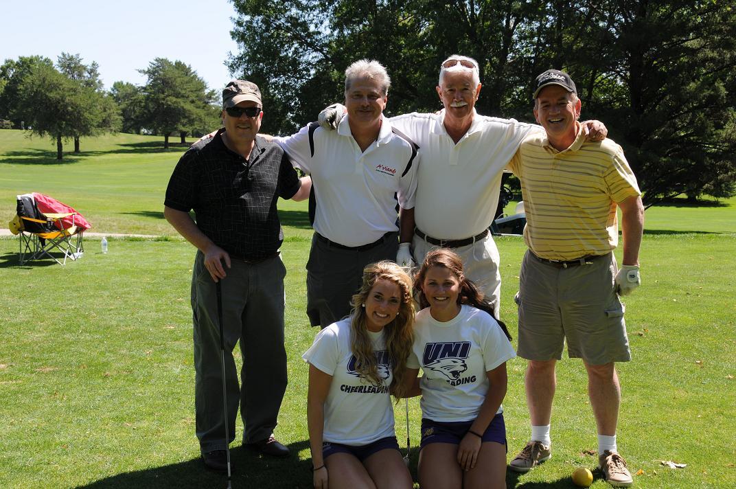 People with UNI t-shirts posing on the golf course for a photo