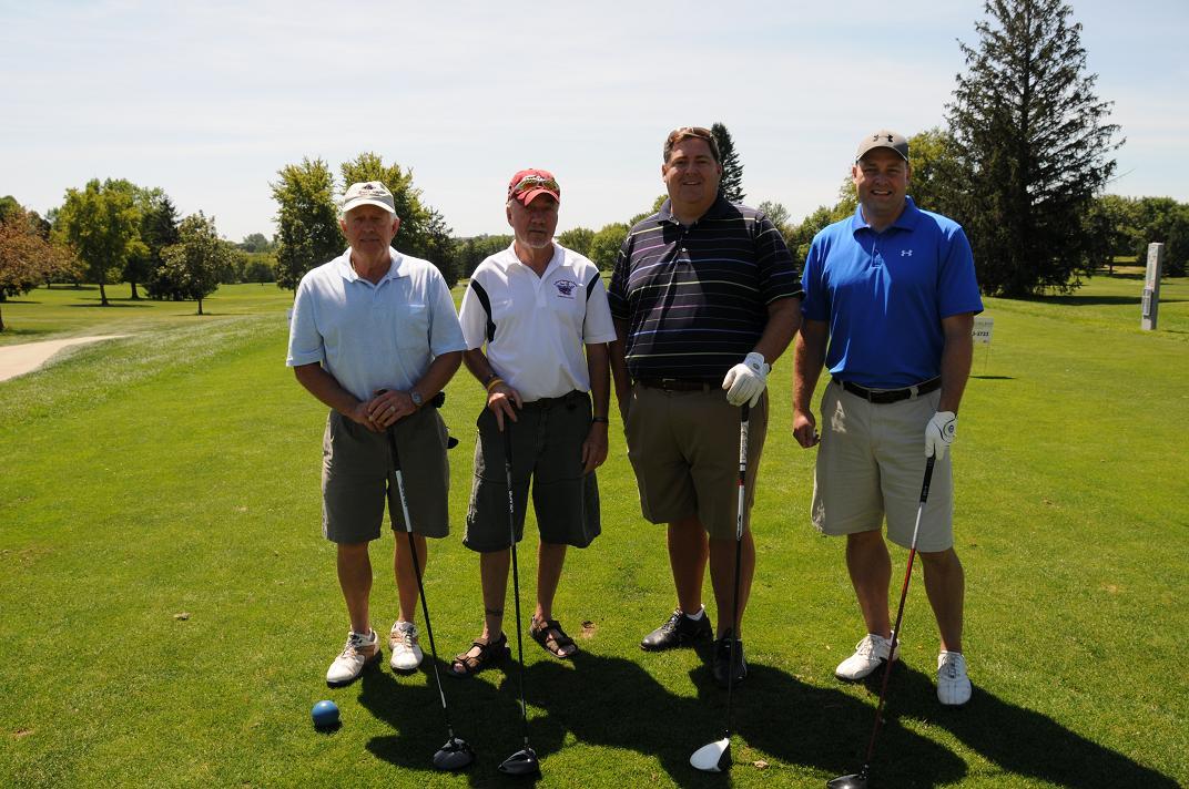 Men on the golf course posing with golf clubs