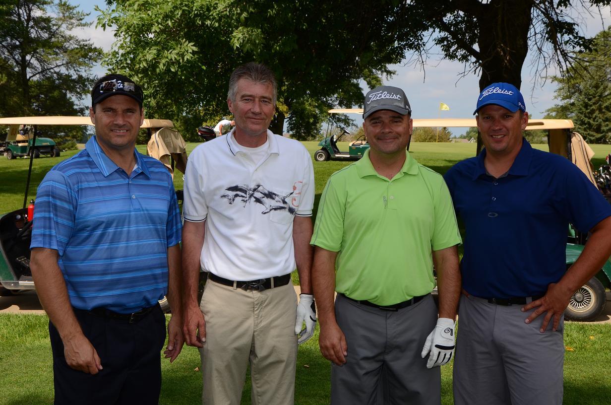 Men wearing golf gear posing for a photo on the course