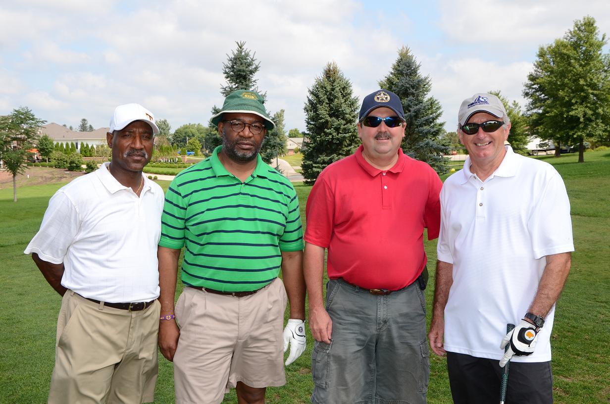 Men on the golf course together posing for a picture