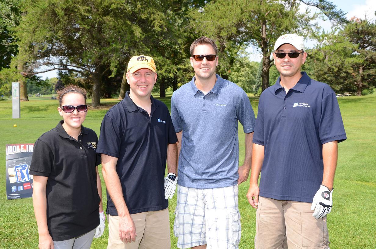 Golfers pose for a photo together outside on the golf course