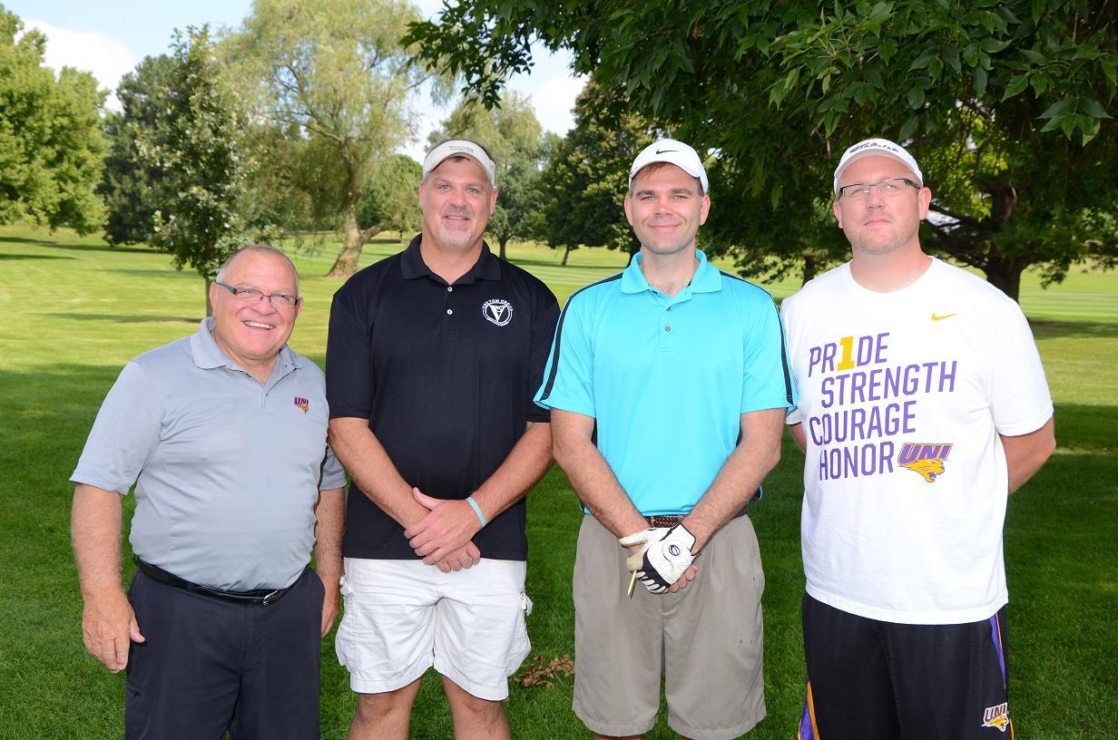 People pose for a photo together on the golf course