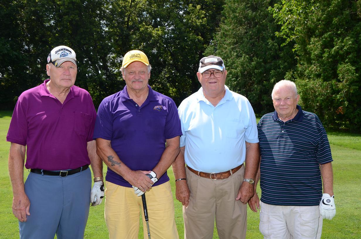 Group of older men on the golf course posing for a photo together
