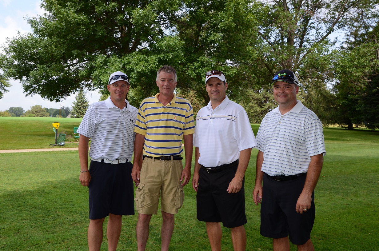 Men stand together on the golf course for a picture