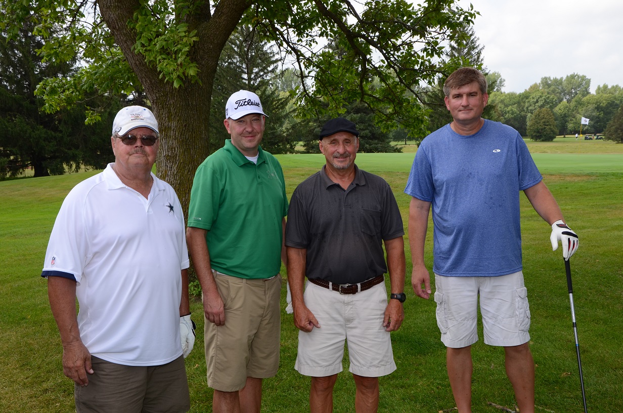 Group of people on the golf course posing for a photo