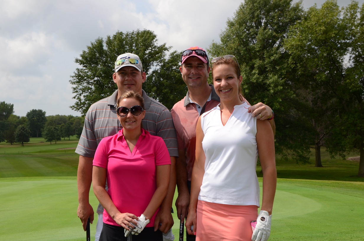 Four people stand in a group for a photo