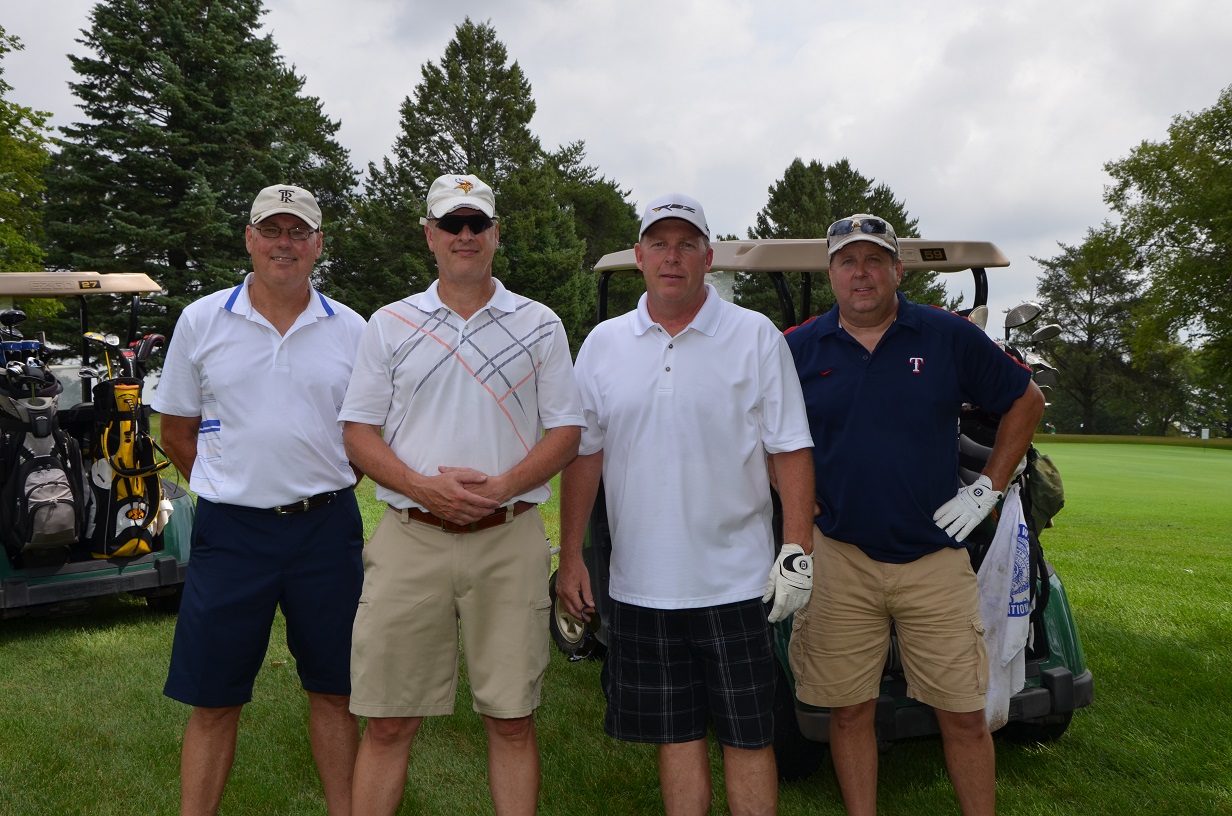 Group of four men posing for a golf photo