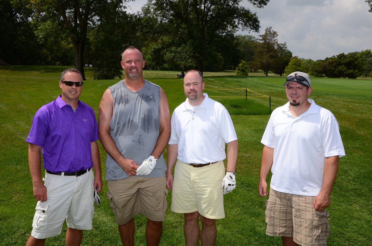 People posing for pictures outside on the golf course