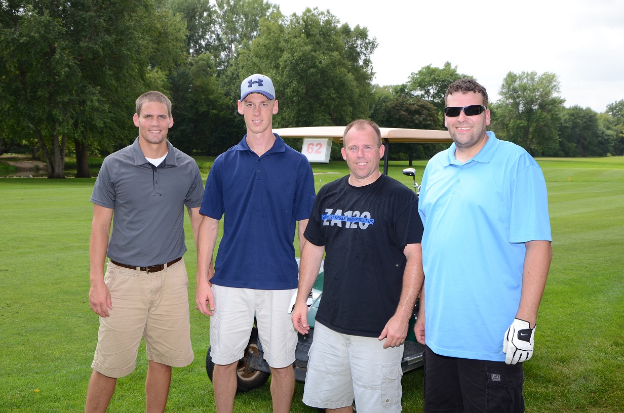 Four people pose for a picture on the golf course