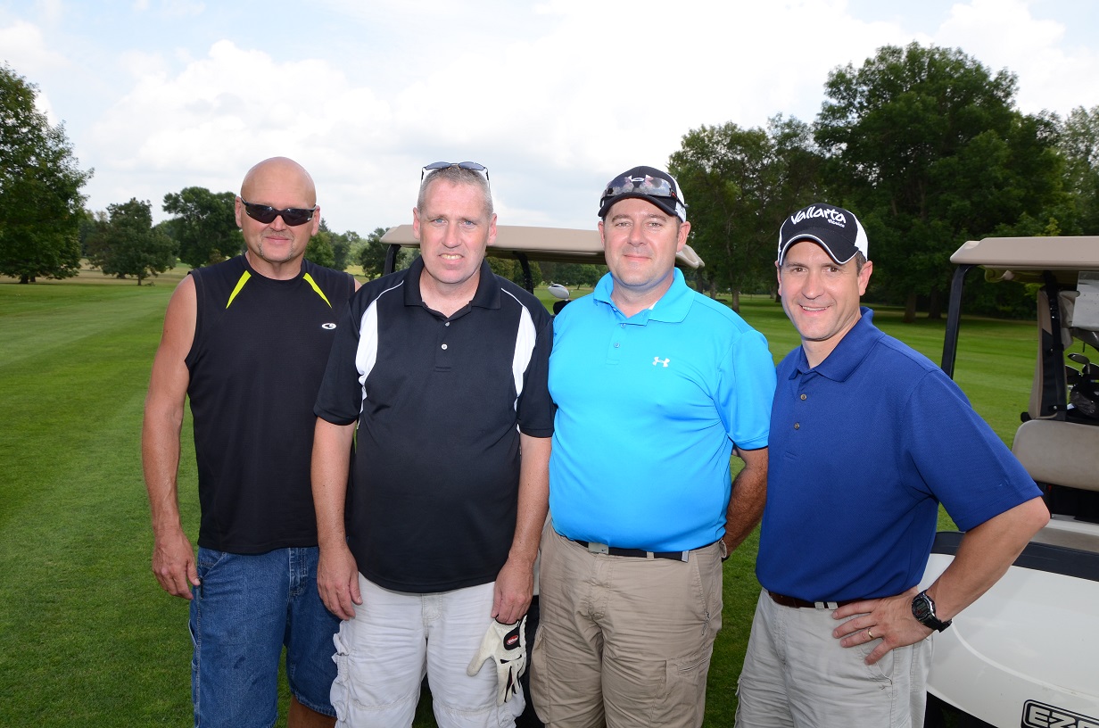 Golfers smile for the camera on the golf course