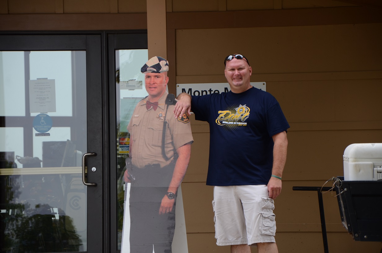 Man posing next to sheriff's cardboard cutout