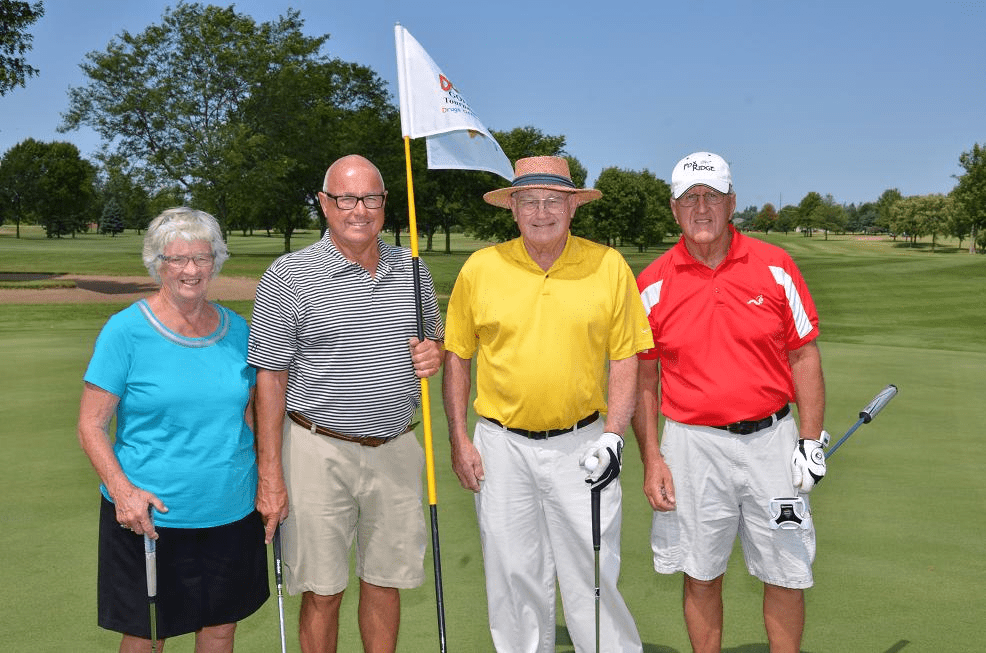 Older group of golfers posing for an photo