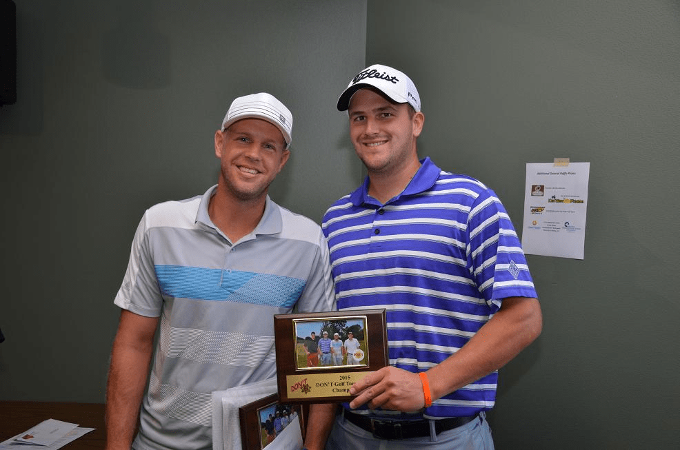 Two men in golf gear posing for a photo