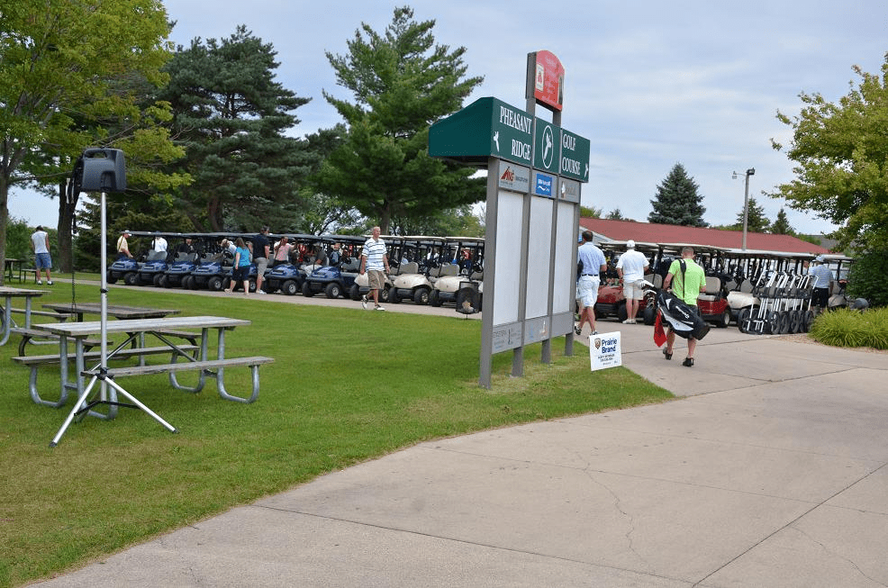 People standing next to golf carts