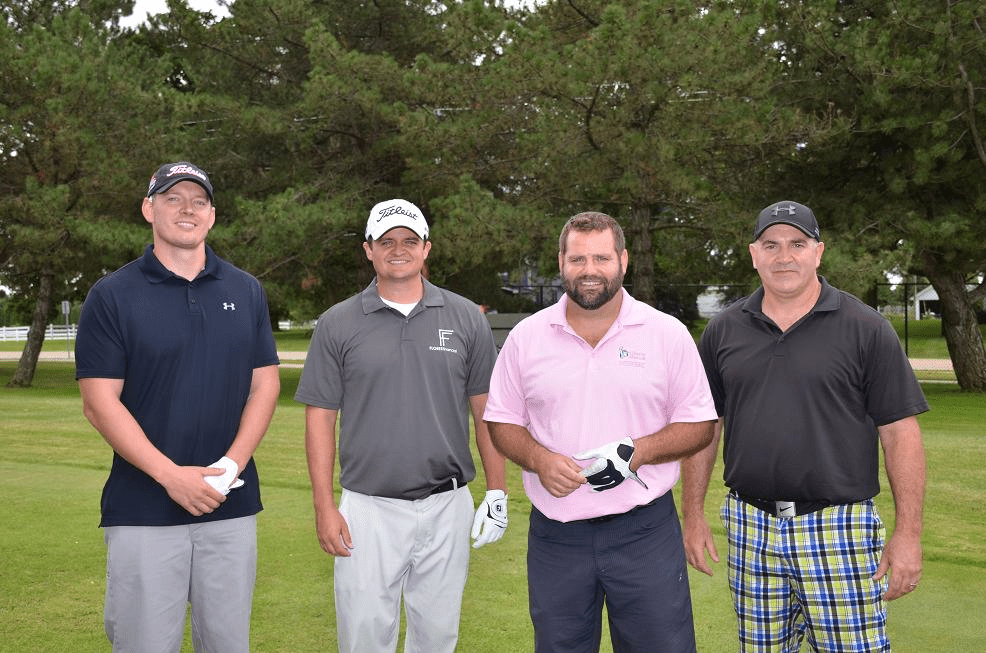 Group of four male golfers posing for a photo