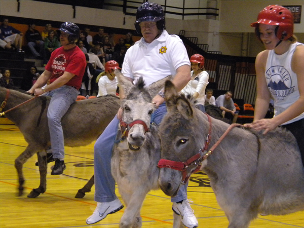 Three people featured riding donkeys