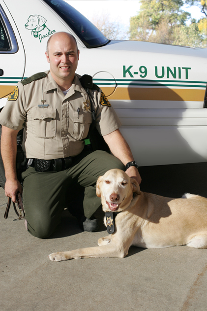 Deputy Harris posing outside with K-9 Jasper