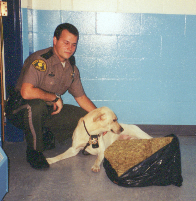 Image of Sergeant Herbst and K-9 AJ with seized item