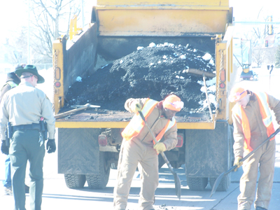 Inmates work to fill the potholes in Waterloo streets