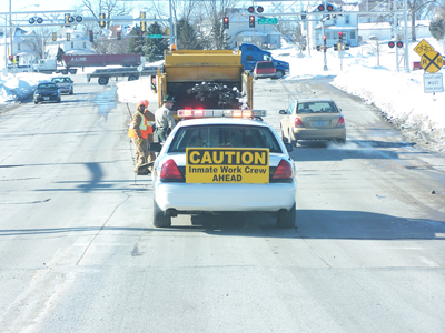 Car and truck warning of inmate work crew ahead