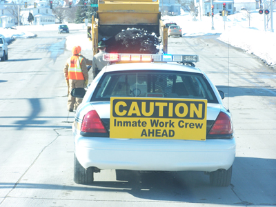 Close up of car with sign to warn of the inmate work car that is ahead