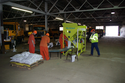 Several inmates handling sandbags