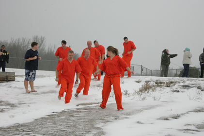 Group of people dressed in orange walking toward the water